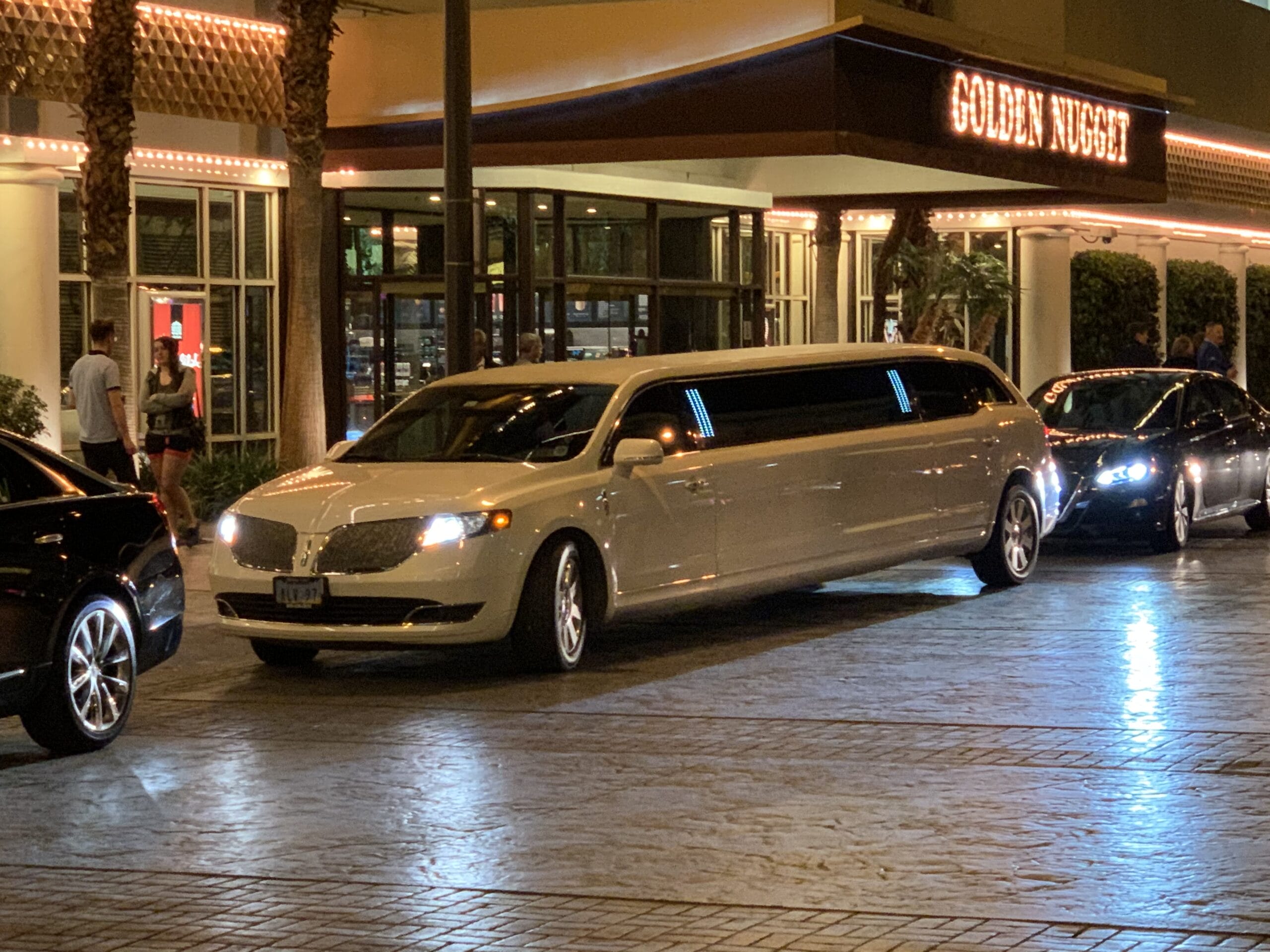 Vegas Limousine Service-36 White limo outside Golden Nugget hotel at night.